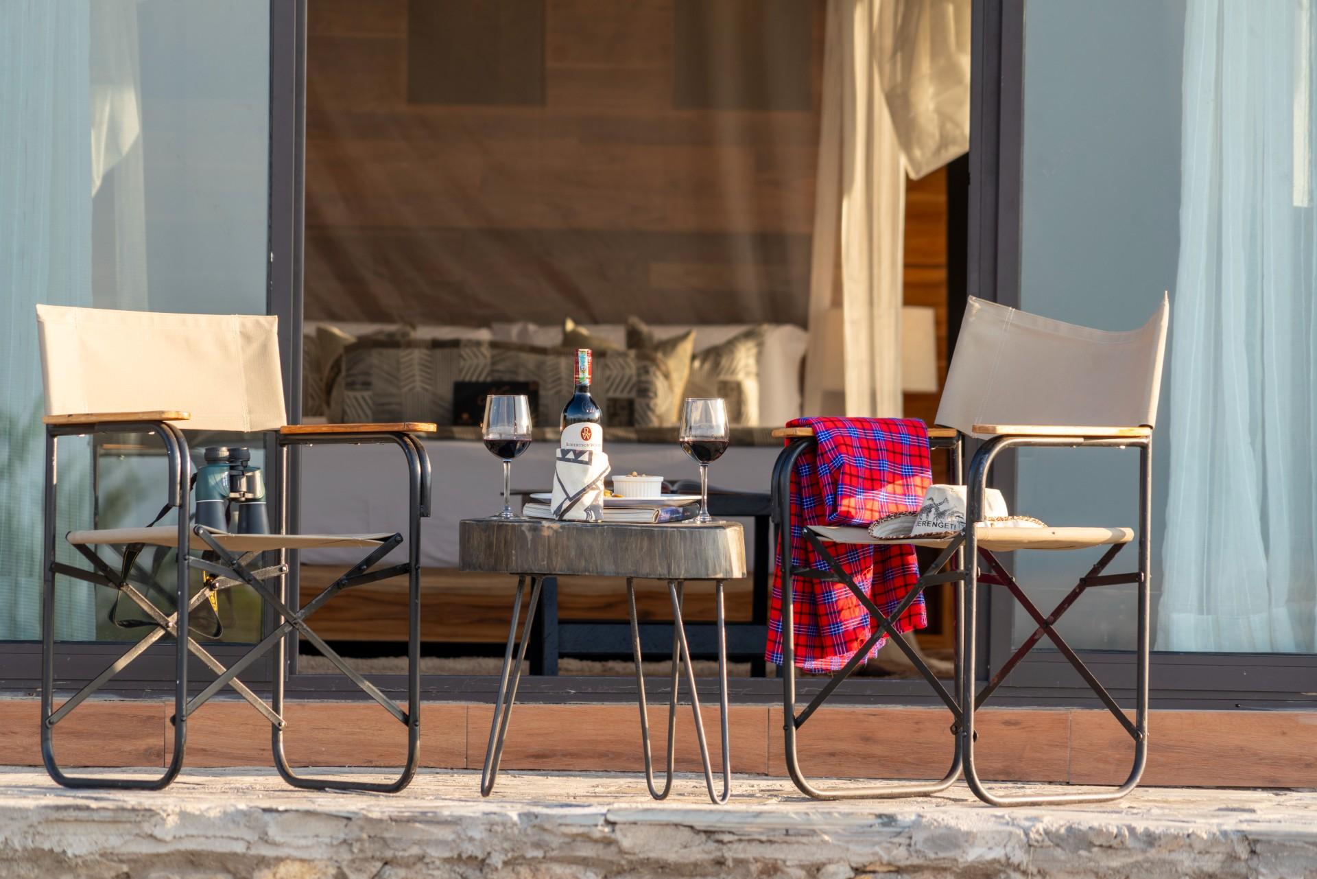 Guests drinking wine outside their double room at River camp
