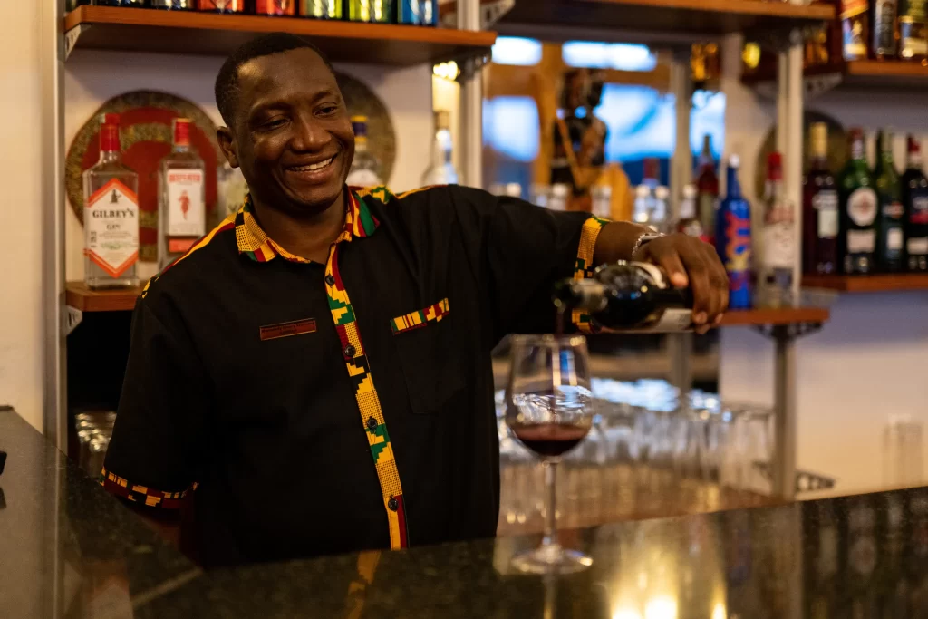 Lion's paw bar tender serving wine at the bar